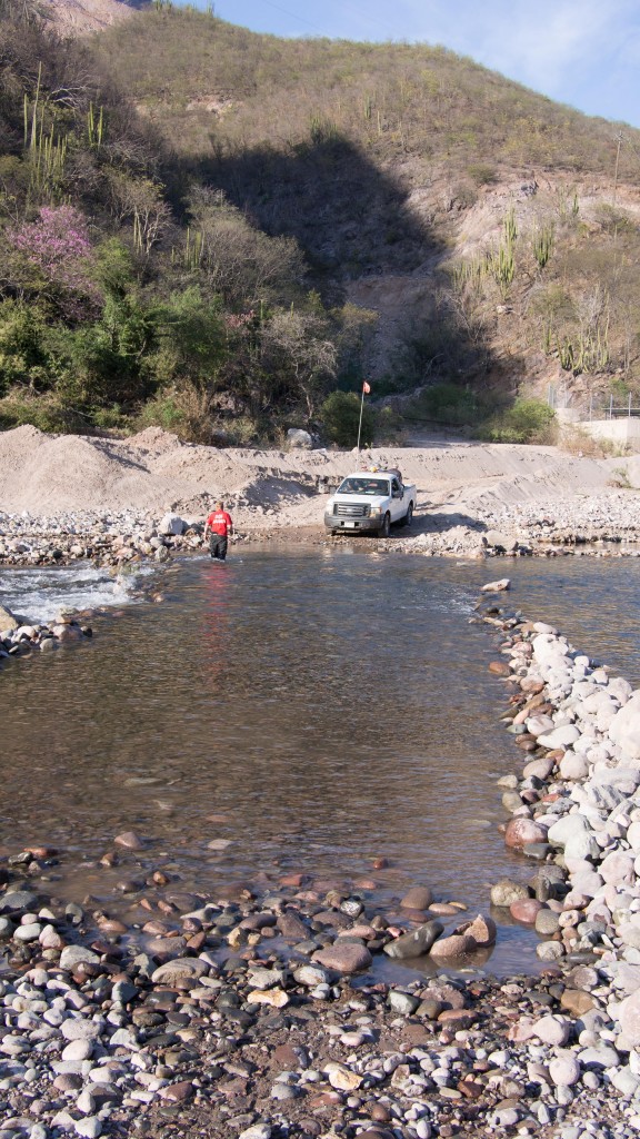 Stefan walking the river, as a truck with luggage and passengers waits to cross.
